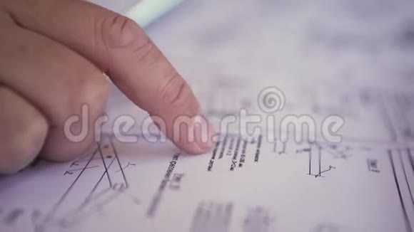 关闭工程师手上的视图指向技术图纸男人的手在纸上显示一些细节蓝图视频的预览图