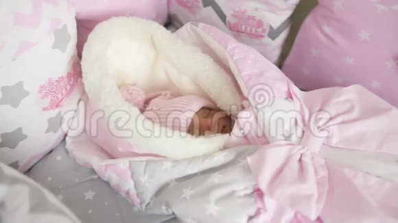 穿着冬季工作服的可爱的女婴睡在婴儿床上睡在透明的天篷床上视频的预览图