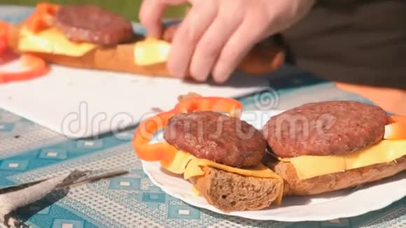 男人用小切片奶酪面包和胡椒做三明治双手特写视频的预览图