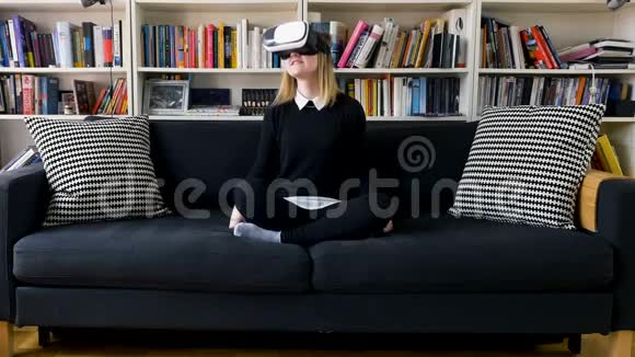 沙发上戴着虚拟现实护目镜的快乐女孩视频的预览图