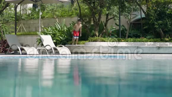 亚洲青少年在花园慢动作中跑进游泳池视频的预览图