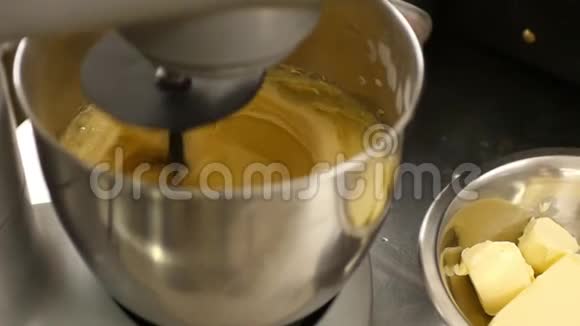 在一家糖果店里一个蛋糕奶油和一个专业的立式搅拌机混合在一起视频的预览图