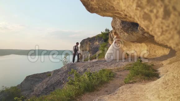 一对夫妇走到海边悬崖一起欣赏风景慢动作视频的预览图