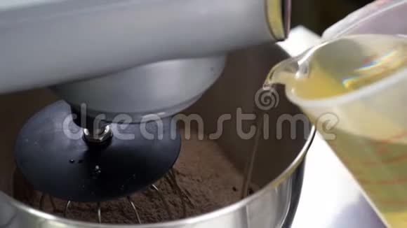 糖果师在盛满面粉的碗里加入油水然后开始搅拌视频的预览图