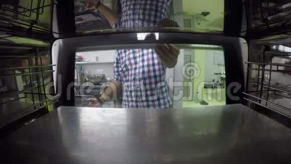 一个人把蛋糕基地放进烤箱的录像视频的预览图
