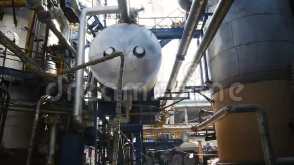 管道和建筑之间的巨大气油罐运动视频的预览图
