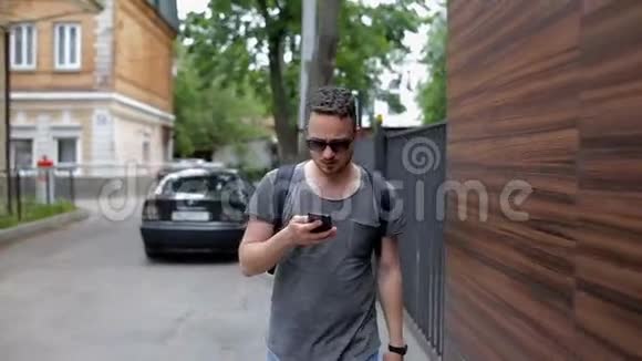 一个男人穿过城市使用智能手机视频的预览图