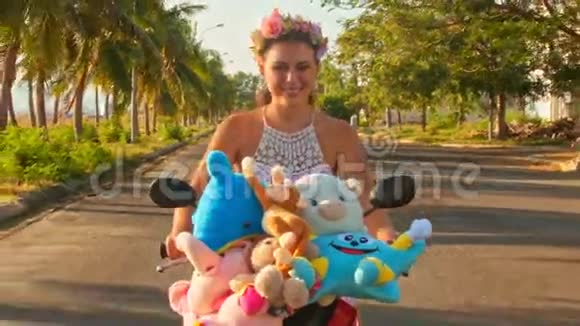 近距离漂亮女孩骑摩托车沿着街道和棕榈视频的预览图