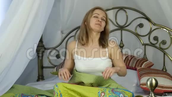 迷人的女人醒来在床上伸展4K视频的预览图