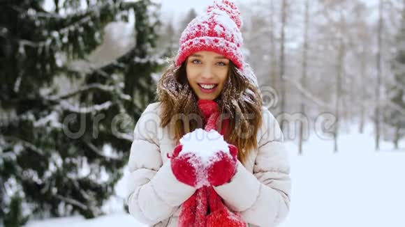 快乐的年轻女子在冬天的森林里撒雪视频的预览图