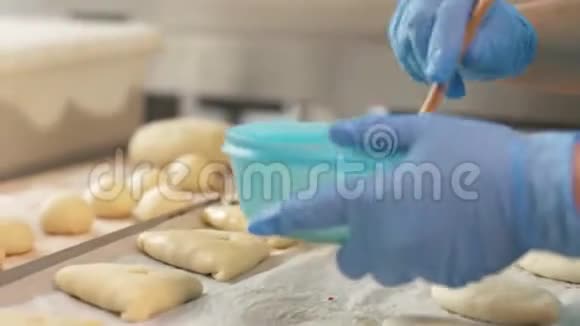 面包师的手在烤桌前用刷子将鸡蛋混合视频的预览图