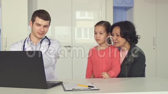 医生给小女孩和她妈妈看了一些笔记本电脑视频的预览图