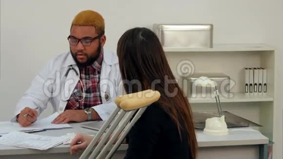 一位非裔美国医生用拐杖给一位年轻妇女送医疗文件视频的预览图