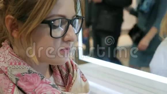 戴眼镜的美女诱人地吃奶油蛋糕女孩的特写享受新鲜馅饼塑料餐具视频的预览图