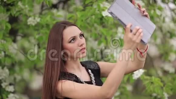 在花园里自拍的年轻女子视频的预览图
