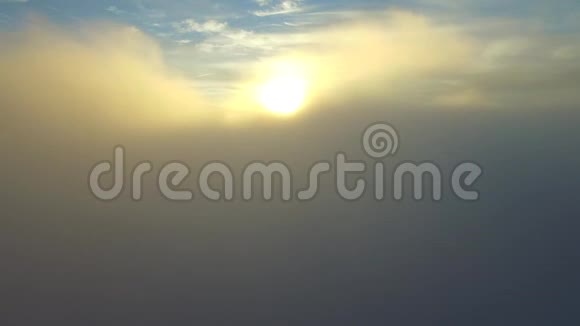 美丽的空中直升机无人驾驶飞机在蓝天黄昏日落阳光云景下的白色雨蓬松云上飞行视频的预览图