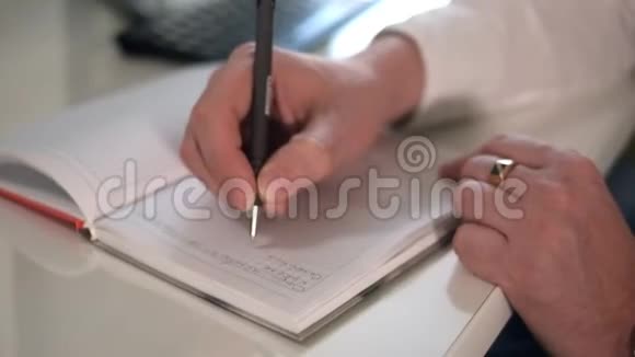 商人在电脑上工作在笔记本上用钢笔做笔记视频的预览图