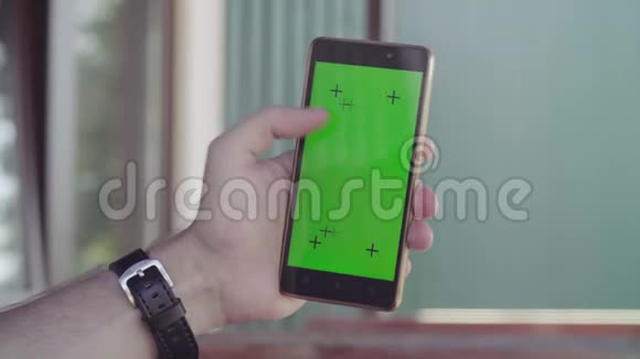 男性手持智能手机绿色屏幕视频的预览图