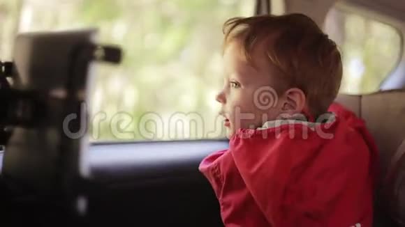 可爱的男孩坐在靠近窗户的婴儿车椅子上等着什么视频的预览图