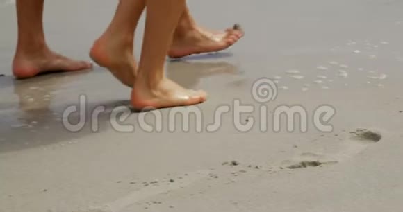 在海滩上光着脚走路的一对夫妇视频的预览图