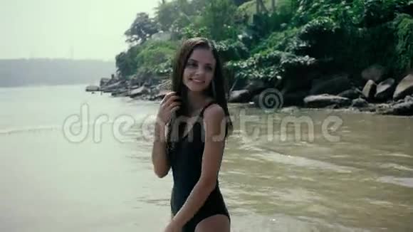 年轻快乐的女人在海滩上摆姿势奔跑快乐的游客在海边视频的预览图