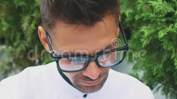 一个穿着商务服装和眼镜的年轻商人站在办公室里视频的预览图