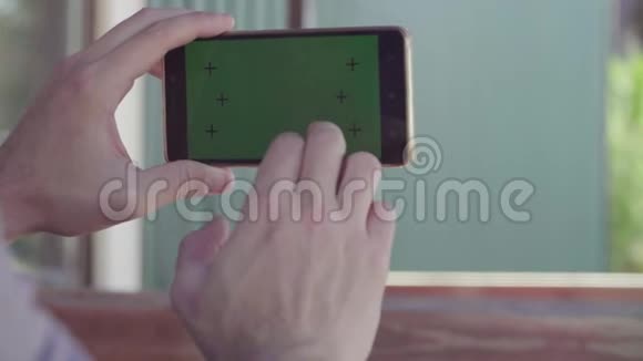 男性手持智能手机绿色屏幕视频的预览图