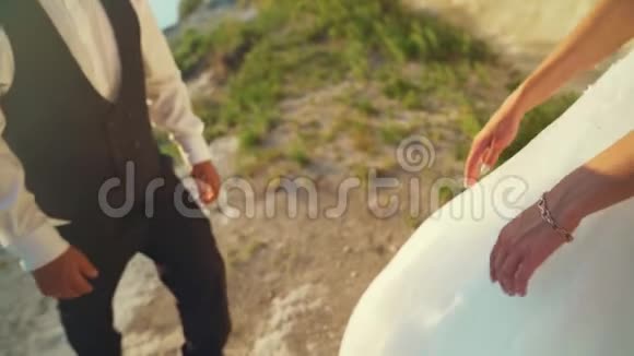 一对夫妇走到海边悬崖一起欣赏风景慢动作视频的预览图