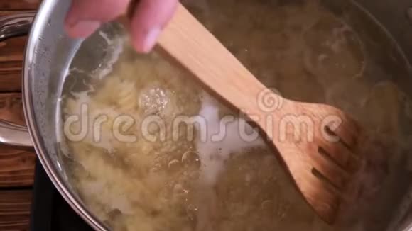 女人在厨房的平底锅里煮意大利面慢动作视频视频的预览图