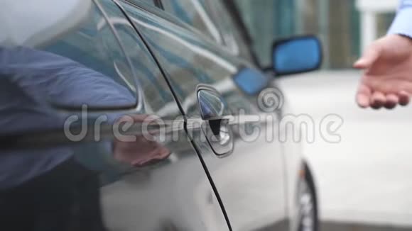 男商人的手为美丽的年轻女子打开并握住车门人为汽车开门视频的预览图