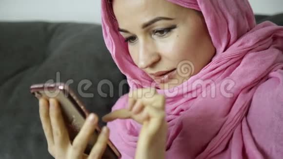 年轻的穆斯林妇女正在和她的朋友聊天戴着头巾的阿拉伯女人手里的手机视频的预览图