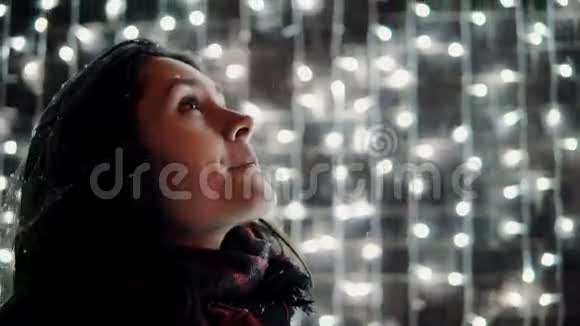 年轻有魅力的女人在圣诞夜玩得很开心舌头掉雪背景灯光视频的预览图