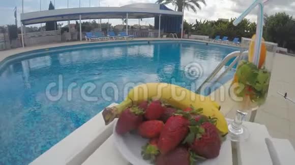 游泳池旁的桌子上有水果和饮料度假酒店聚会视频的预览图