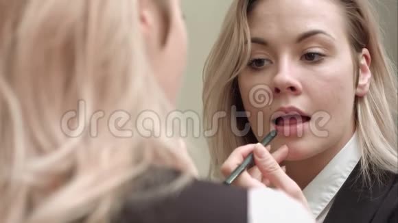 年轻漂亮的女人涂着红唇膏视频的预览图