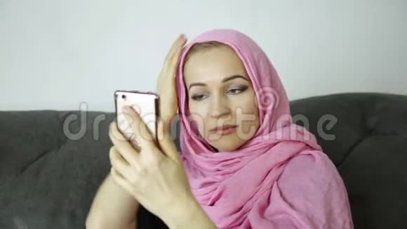 戴着头巾的阿拉伯女人在手机上和朋友聊天视频的预览图