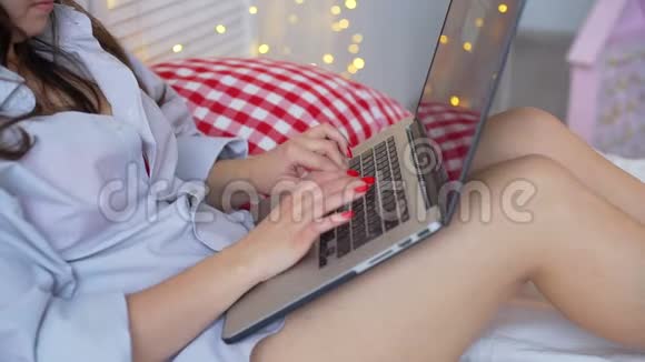 坐在床上用笔记本电脑打字的女人视频的预览图