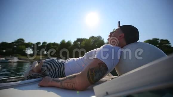 日落时分一个成功的人躺在游艇上视频的预览图