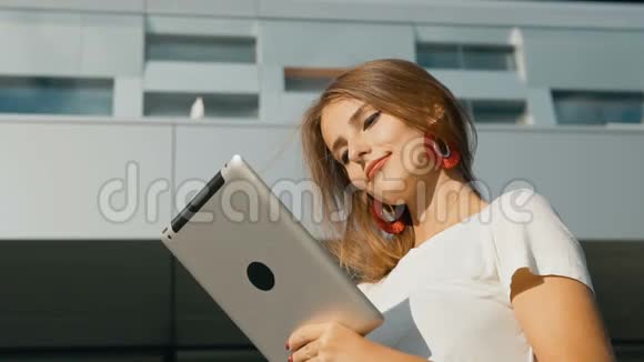 女孩在现代公司前使用平板电脑视频的预览图