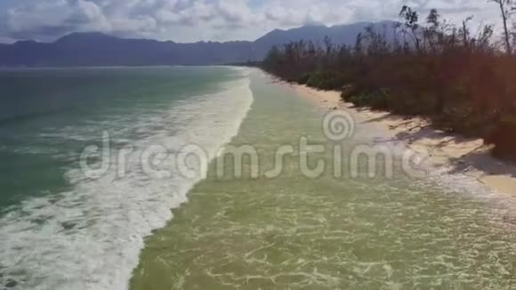 沿沙滩靠近Azure海浪冲浪的无人机视频的预览图