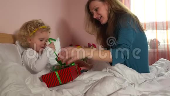 欢乐的母女在卧室里打开礼物盒视频的预览图