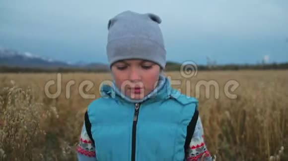 小女孩走在麦田里孩子奔跑的背景是美丽的山脉和白雪覆盖的山峰儿童视频的预览图