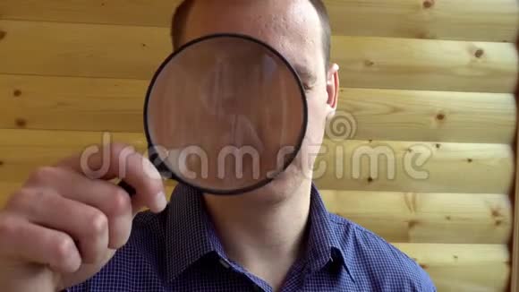 一个好奇的人用放大镜看着摄像机的大脸一只侦探的私家侦探视频的预览图