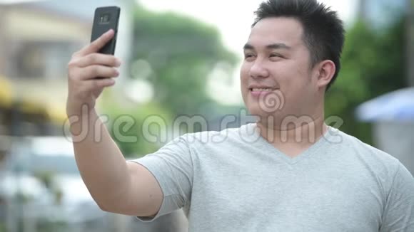 年轻英俊体重超重的亚洲男人在户外街头视频的预览图