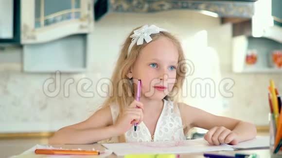 可爱的小女孩坐在桌子旁用铅笔画画视频的预览图