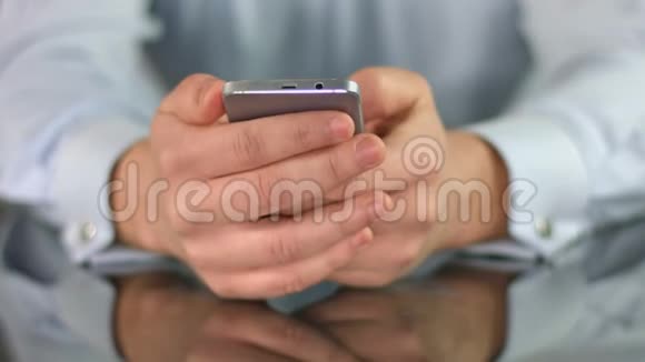 男人在智能手机上看电影双手滚动屏幕特写视频的预览图