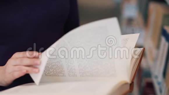 女孩把手指放在图书馆看书的书页上视频的预览图