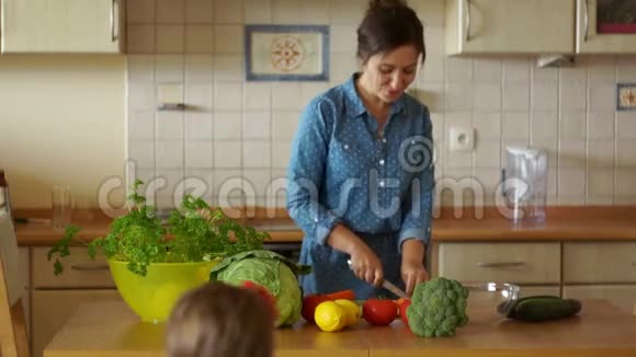 年轻的父母和他们的小女儿一起在厨房做饭家庭晚餐妈妈助理快乐视频的预览图