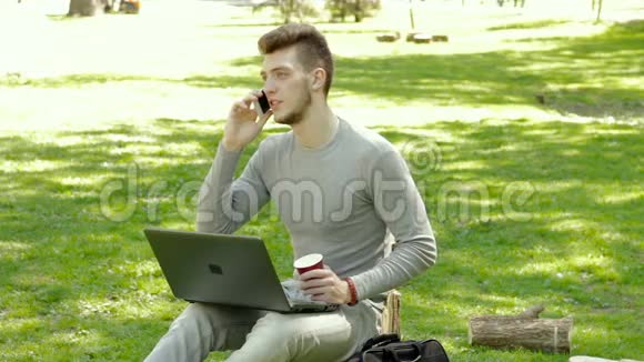 公园里的人打电话用手提电脑喝咖啡视频的预览图