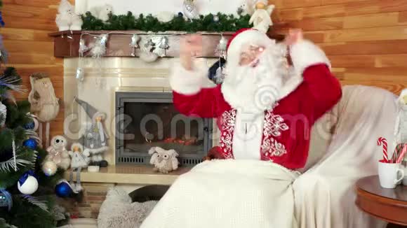 跳舞的圣诞老人有壁炉的房间坐在椅子上玩得开心视频的预览图