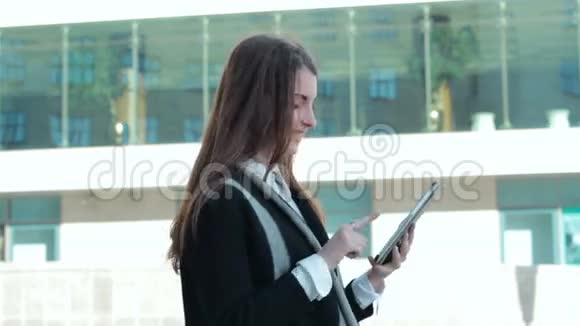 年轻女子在街上使用移动平板电脑视频的预览图